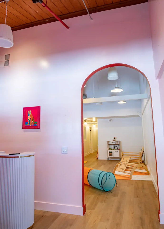 Arched doorway with a red frame leading to another room.